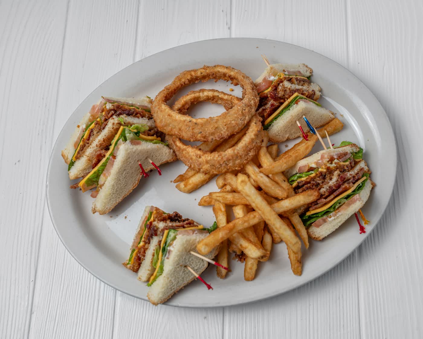 Club sandwich with fries and onion rings